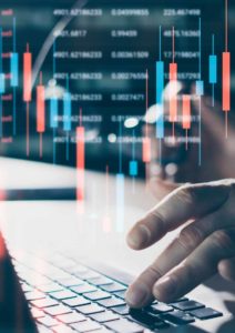 Hands typing on a keyboard with overlaid stock market graphs and data, seamlessly integrating insights from MDR services to enhance decision-making precision.