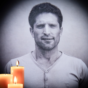  Retrato en blanco y negro de un hombre con cabello corto y camiseta, junto a tres velas encendidas, resaltando la serenidad que contrasta con su rol en Detección y respuesta gestionadas.
