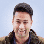  A person wearing a jacket smiles against a light blue background, embodying the calm confidence of an expert in MDR solutions.