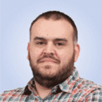  Man with a beard, embodying the essence of SecOps, wears a plaid shirt against a plain background.