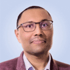  A person wearing glasses and a blazer, embodying the essence of MxDR expertise, looks directly ahead against a light blue background.