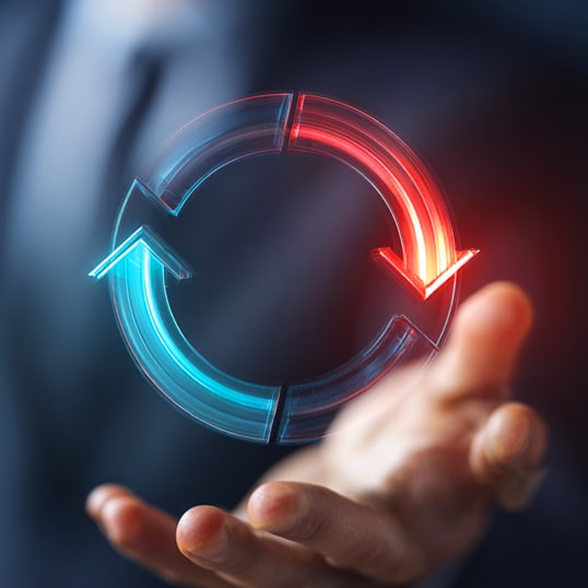  A person holds out a hand beneath a glowing circular arrow graphic, half blue and half red, representing how to optimize security budget through a continuous cycle or process.